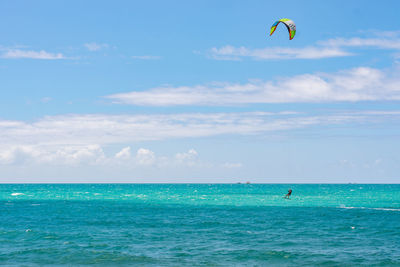 View of a unrecognizable person kiteboarding on the ocean against clear sky