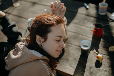 High angle view of young woman sitting by table