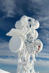 Low angle view of  icy telecommunication repeater against  sky