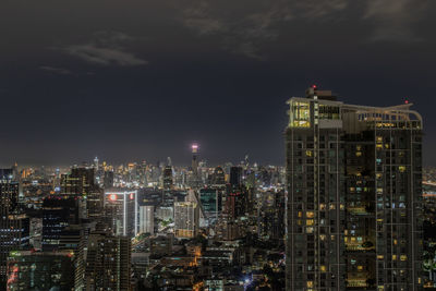 Illuminated buildings in city against sky at night