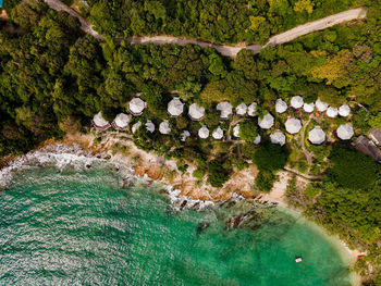 The top view of beautiful blue seashore and rocky on coast and white bungalow on the beach