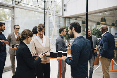 Male and female entrepreneurs talking while standing in office
