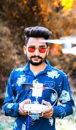 Portrait of young man wearing sunglasses standing outdoors