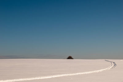 Scenic view of land against clear sky during winter