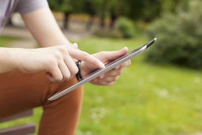 Midsection of woman holding mobile phone