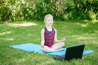 Full length of woman sitting on field