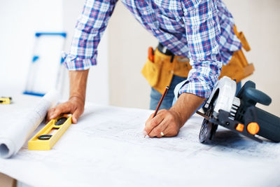 Midsection of man working at workshop