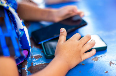 Cropped hands of woman using mobile phone