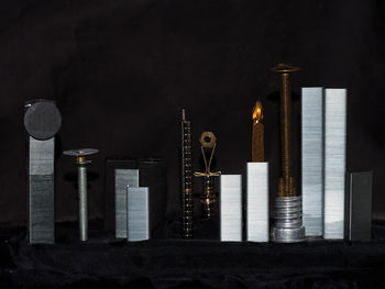 Close-up of illuminated lighting equipment on table against wall