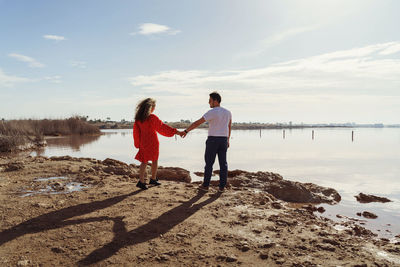 Full length of couple standing on beach