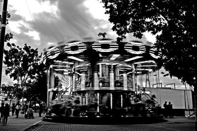 Carousel in city against sky
