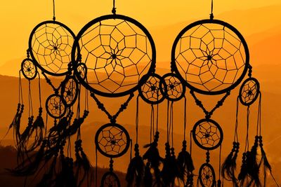 Low angle view of illuminated chandelier against sky during sunset