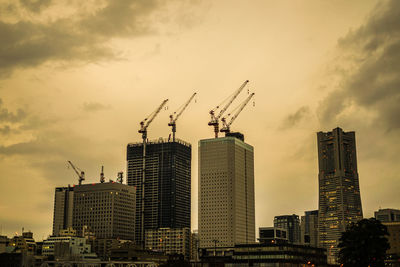 Modern buildings in city against sky during sunset