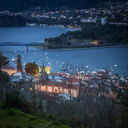 High angle view of illuminated buildings by river at night