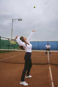 The newlyweds play tennis on the court symbolizing family relations
