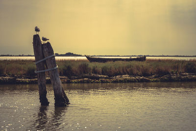 Man standing by lake against sky