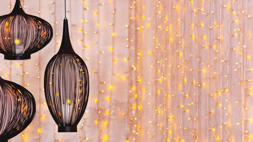 Black ethnic lanterns on background with light bulbs. eastern lamps on festive ramadan background. 