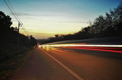 Traffic on road at sunset