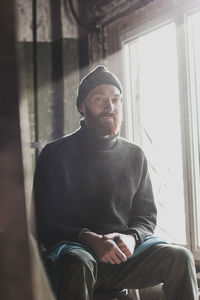 Young man looking through window