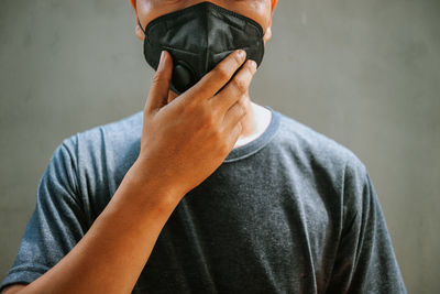 Midsection of man wearing pollution mask