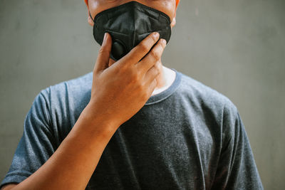 Midsection of man holding hands against wall