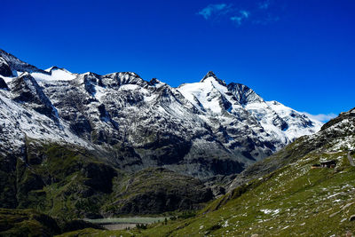 Scenic view of snowcapped mountains against blue sky