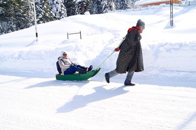 People on playing on snow covered land