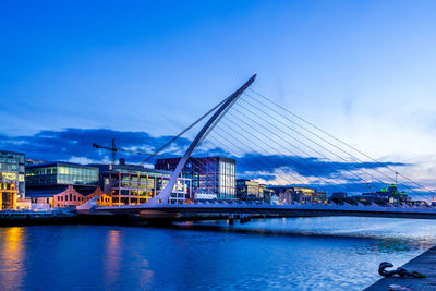 Buildings by river against sky