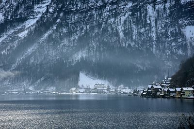 Scenic view of lake by mountains during winter