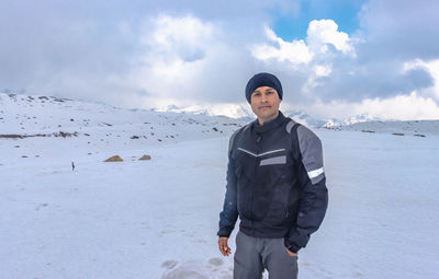 Portrait of young man standing in snow