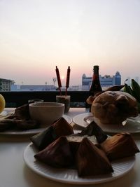 Close-up of food on table against sky during sunset
