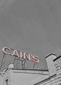 Low angle view of text on building against sky