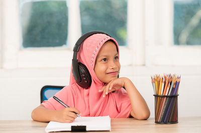 Portrait of a smiling girl sitting on table