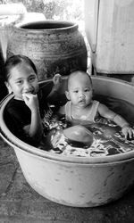 Portrait of brother and sister sitting in container