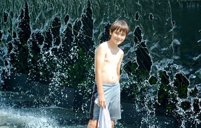 Portrait of shirtless boy standing in water