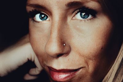 Close-up portrait of woman against black background