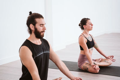 Man and woman doing yoga on floor 