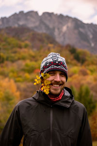 Portrait of man wearing hat standing against mountain