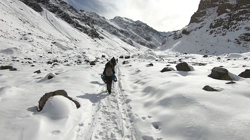 People on snow covered mountain against sky