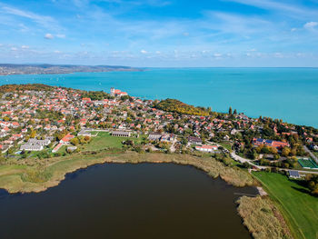Aerial view of town by sea against sky