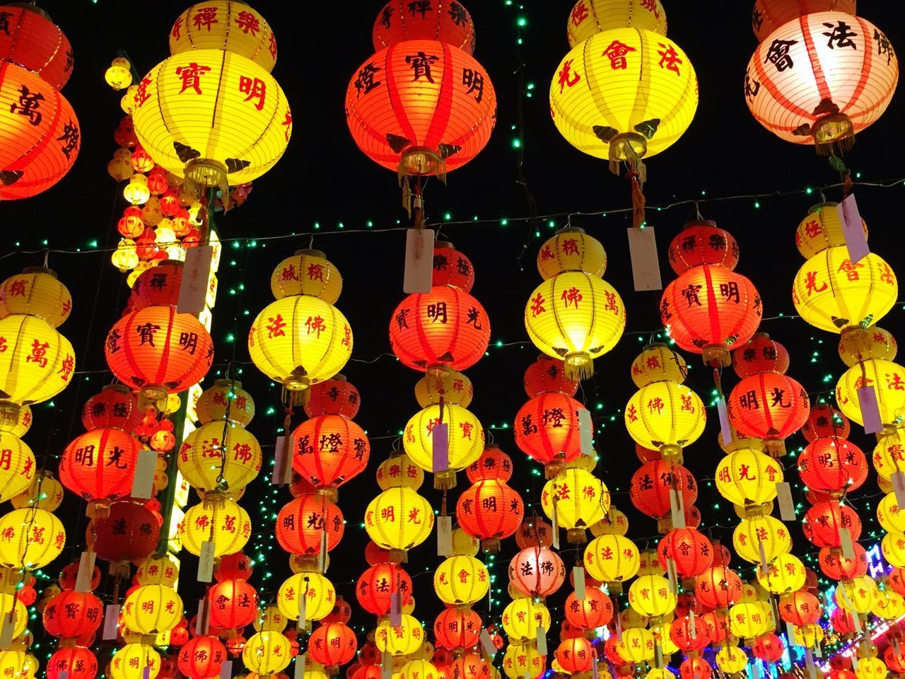 LOW ANGLE VIEW OF ILLUMINATED LANTERNS HANGING ON NIGHT