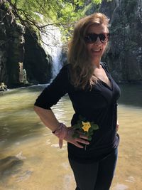 Smiling young woman wearing sunglasses standing outdoors