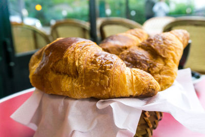 Croissants on tissue papers over basket