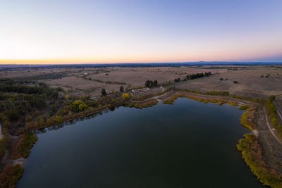 Scenic view of lake against clear sky during sunset