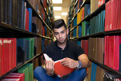 Portrait of young man sitting in library