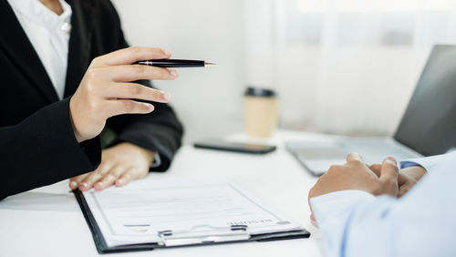 Midsection of businessman working on table