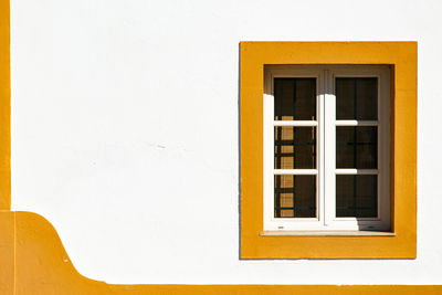 Close-up of yellow window on wall of building