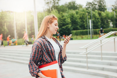 Young woman using smart phone in city