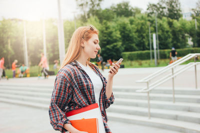 Young student using smart phone at campus