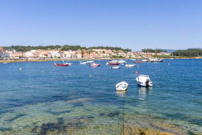 Sailboats in sea against clear blue sky